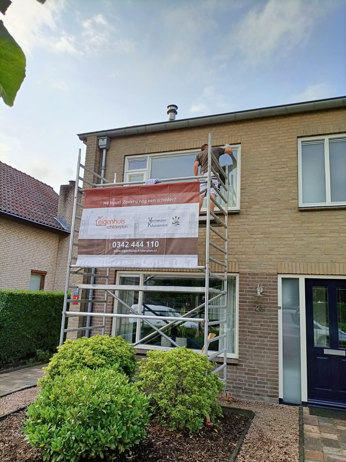 Schilderwerk in uitvoering op steiger in Hilversum
